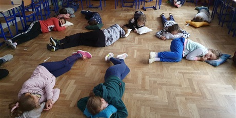 Powiększ grafikę: Uczniowie leżą i słuchają muzyki relaksacyjnej. 