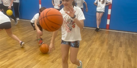 Powiększ grafikę: Natalia kozłuje jednocześnie dwie piłki od koszykówki.