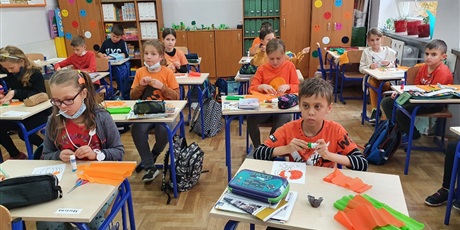 Powiększ grafikę: Dzieci z klasy 3a wykonują prace plastyczną - wyklejanie szablonu dyni. Na pierwszym planie Adaś, Martyna, Asia i Janek.