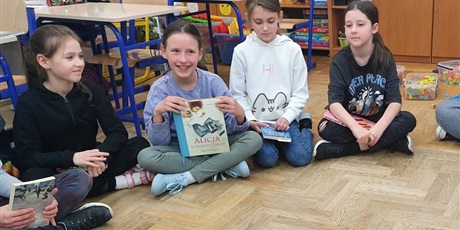 Powiększ grafikę: Dzieci siedząc w kręgu opowiadają o swoich ulubionych książkach