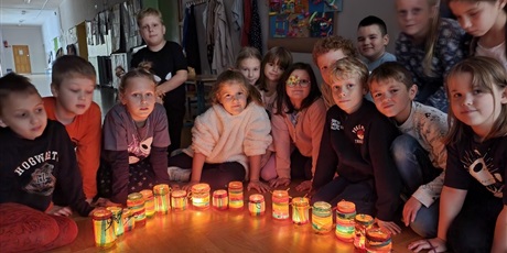 Powiększ grafikę: 2-3 - Dzieci prezentują swoje lampiony z zapalonymi świeczkami.