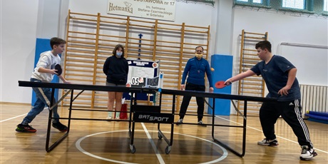 Powiększ grafikę: Marcel i Jakub grają finałowy turniej w tenisa stołowego na sali gimnastycznej.