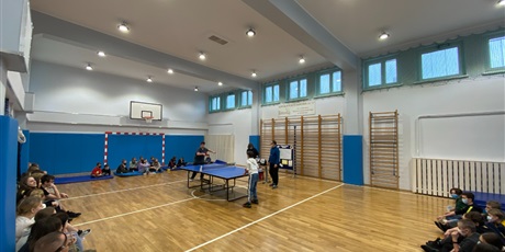 Powiększ grafikę: Marcel i Jakub grają finałowy turniej w tenisa stołowego na sali gimnastycznej.