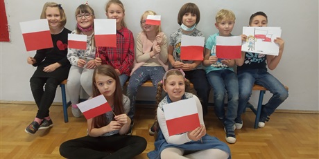 Powiększ grafikę: Uczniowie z wykonanymi przez siebie flagami.